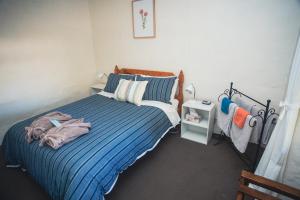 a bedroom with a bed with a blue comforter at Kooringa Cottage in Burra