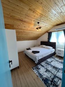 Sea Life Homes في كيمير: غرفة نوم بسرير وسقف خشبي
