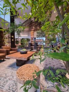 um átrio com uma mesa, cadeiras e árvores em Brittany Hotel BGC em Manila