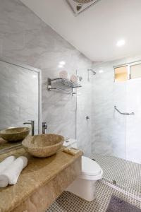La salle de bains est pourvue d'un lavabo, de toilettes et d'une douche. dans l'établissement Brisa Color Esmeralda, à Brisas de Zicatela