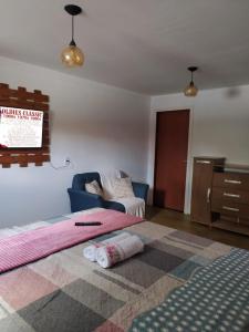 - un salon avec deux lits et un canapé dans l'établissement Chalés Rosados, à Serra de São Bento
