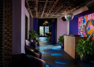 una hall con bar con pareti e sedie viola di Virgin Hotels Chicago a Chicago