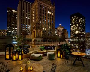 a rooftop patio with a view of a city at night at Virgin Hotels Chicago in Chicago