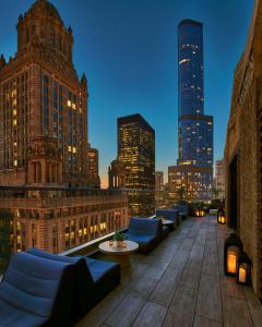 a rooftop patio with couches and a city skyline at night at Virgin Hotels Chicago in Chicago