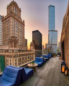 a rooftop patio with blue couches and a city skyline at Virgin Hotels Chicago in Chicago