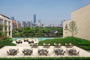 un patio con tavoli e sedie e vista sulla città di The Grand Mansion Hotel,Nanjing a Nanjing