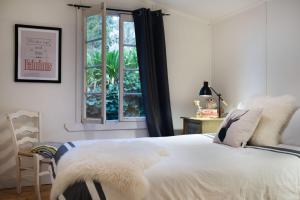1 dormitorio con cama blanca y ventana en Botanica, en Daylesford