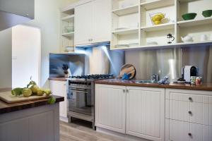 a kitchen with white cabinets and a stove top oven at Botanica in Daylesford