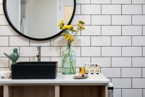 a bathroom with a sink and a vase with flowers at Botanica in Daylesford