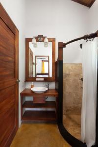 ein Bad mit einem Waschbecken und einem Spiegel in der Unterkunft Casa Yosi, Beach Front Piece of Heaven in San Juan del Sur