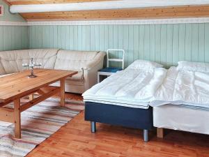Habitación con 2 camas, mesa y sofá en Holiday home Husum, en Husum