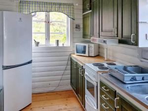 a kitchen with green cabinets and a white refrigerator at Holiday home Husum in Husum