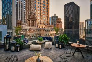 a rooftop patio with tables and chairs and a city skyline at Virgin Hotels Chicago in Chicago