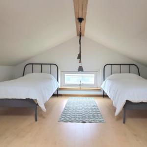 two beds in a attic bedroom with a window at A shell in Jeju in Seogwipo