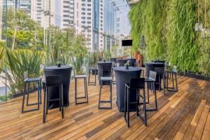 un bar con sedie e tavoli su una terrazza in legno di Live Aqua Ciudad de Mexico Bosques de las Lomas a Città del Messico