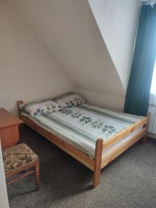 ein kleines Bett in einem Zimmer mit Bettrahmen in der Unterkunft Gościniec IBIS in Czarna Wieś