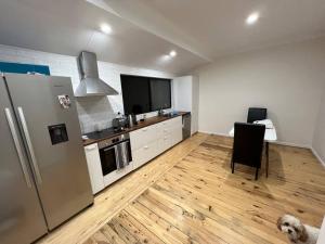 a kitchen with a refrigerator and a table with a dog at The Cottage in Queanbeyan