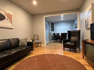 a living room with a couch and chairs and a television at The Cottage in Queanbeyan