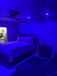 a blue bedroom with a bed and a ceiling fan at City View Luxury Home in Montego Bay