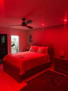 a red bedroom with a bed and a ceiling fan at City View Luxury Home in Montego Bay