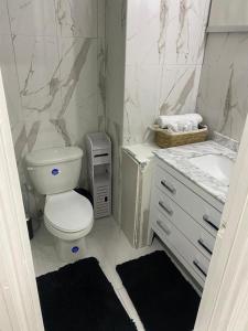 uma casa de banho branca com um WC e um lavatório em City View Luxury Home em Montego Bay