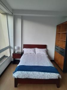 um quarto com uma cama grande e uma janela em Aparta Suite La Candelaria em Bogotá