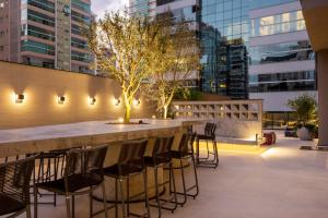 um bar no telhado de um edifício com cadeiras em I Am Design Hotel Itapema by Hotelaria Brasil em Itapema