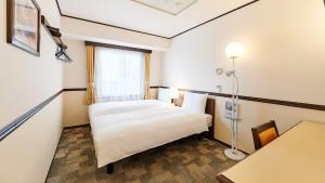 Toyoko Inn Kashiwa eki Nishi guchi في كاشيوا: غرفه فندقيه بسرير ونافذه