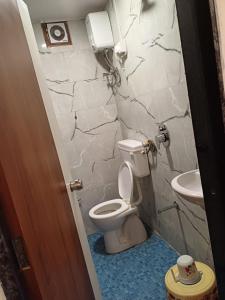 a bathroom with a toilet and a sink at HOTEL EAGLE INN, NARODA in Ahmedabad