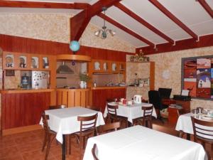 un restaurante con mesas y sillas blancas y una cocina en Hostal Solor, en San Pedro de Atacama