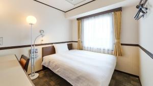 a small room with a bed and a window at Toyoko Inn Kashiwa eki Nishi guchi in Kashiwa