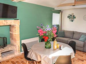 uma sala de estar com uma mesa com um vaso de flores em Gîte Joué-lès-Tours, 2 pièces, 3 personnes - FR-1-381-545 em Joué-lés-Tours