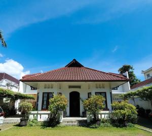 a white house with a red roof at Kutus Kutus Clemmie Huis in Yogyakarta