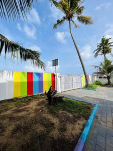 科欽的住宿－Chameleon Beach Resort, Cherai，色彩缤纷的围栏,棕榈树和篮球架