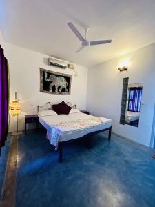 Chameleon Beach Resort, Cherai في كوتشي: غرفة نوم بسرير ومروحة سقف