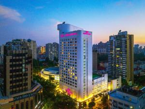 un edificio illuminato in una città di notte di Crowne Plaza Shanghai, an IHG Hotel a Shanghai