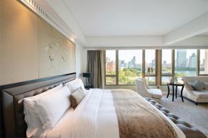 a bedroom with a large bed and a large window at Marco Polo Xiamen in Xiamen