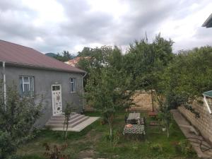 a yard with a house and a table and chairs at Elchins villa in Gabala