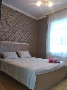 1 dormitorio con 1 cama blanca grande y ventana en Elchins villa, en Gabala