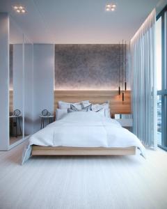I Am Design Hotel Itapema by Hotelaria Brasil في ايتابيما: غرفة نوم بسرير ابيض كبير ونوافذ كبيرة