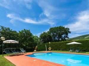 カスティリオーン・フィオレンティーノにあるSpacious Farmhouse in Castiglion Fiorentino with Gardenのスイミングプール(椅子2脚、パラソル付)