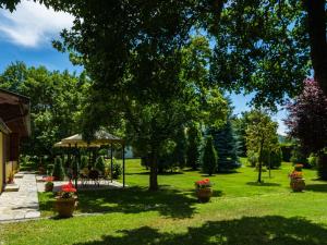 un cortile con gazebo e fiori in vasi di Spacious Farmhouse in Castiglion Fiorentino with Garden a Castiglion Fiorentino