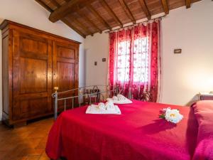 um quarto com uma cama vermelha e toalhas em Spacious Farmhouse in Castiglion Fiorentino with Garden em Castiglion Fiorentino