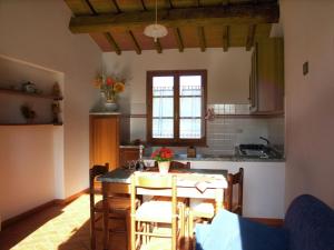 uma cozinha e sala de jantar com mesa e cadeiras em Spacious Farmhouse in Castiglion Fiorentino with Garden em Castiglion Fiorentino