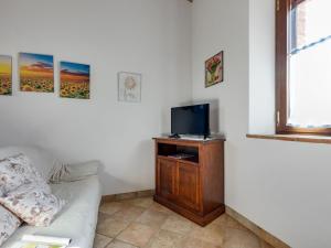 ein Wohnzimmer mit einem Sofa und einem TV in der Unterkunft 360 degree view over the Tuscan hills in Buonconvento