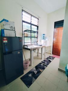 a kitchen with a table and a refrigerator at Miza Homestay in Kuala Terengganu