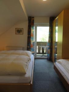 ワイレックにあるFerienwohnungen Bachbauerのベッドルーム1室(ベッド2台、大きな窓付)