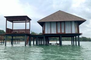 two houses on stilts in the water at Leebong Island Resort in Leebong