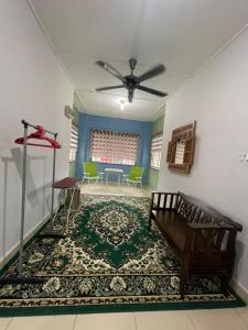 a living room with a ceiling fan and a rug at Hidayah Homestay Tawau in Kampong Parit