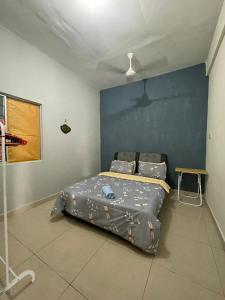 Schlafzimmer mit einem Bett mit blauer Wand in der Unterkunft Hidayah Homestay Tawau in Kampong Parit